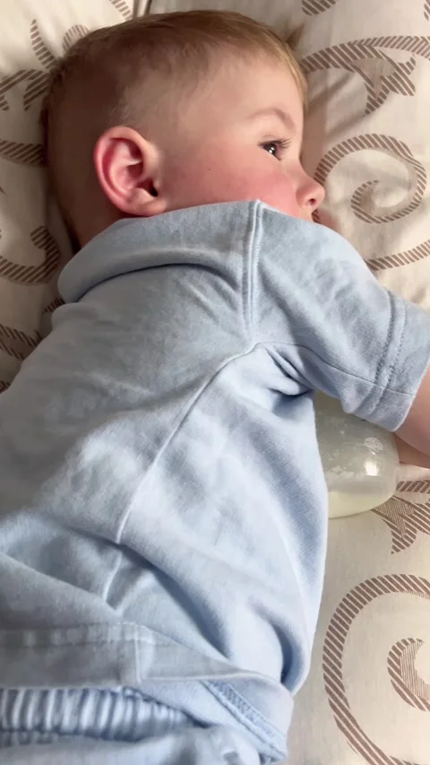 A small child falls asleep during the day hugging a bottle of milk Stock Footage 310315959