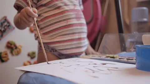 A small child the first time draws paints on paper Stock Footage 73823378