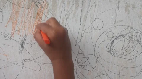 A small child hand is scribbling on a white wall with a crayon. Stock Footage 327731279
