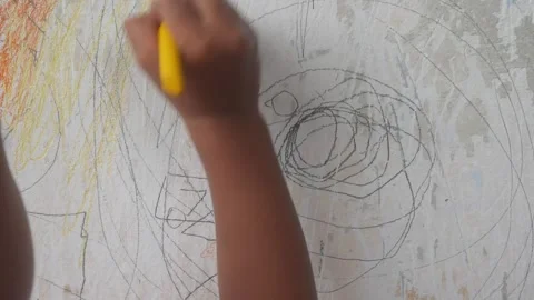 A small child hand is scribbling on a white wall with a crayon. Stock-Footage 327731299