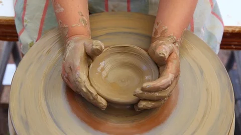 Small child hands making clay pot on the ceramic wheel, kid learning pottery Stock Footage