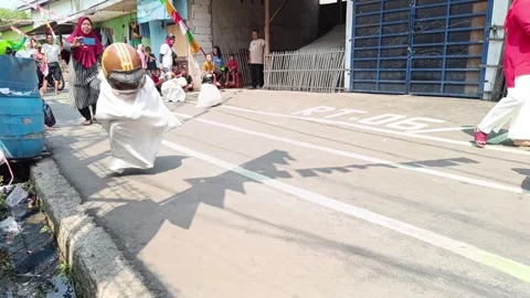 A small child is having a sack race to celebrate Indonesia's independence day Stock Footage 248230904