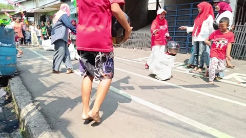 A small child is having a sack race to celebrate Indonesia's independence day Stock Footage 248230920