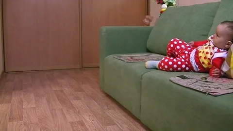 A small child himself to go down from the sofa Stock Footage 89571000