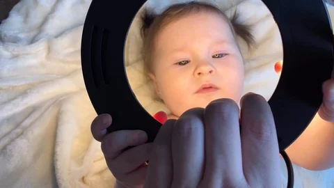 Small child holding a circular light for selfie Stock Footage 123689464