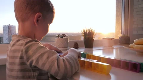 Small Child Independently Plays Constructor On Table By The Window At Sunset Stock Footage 233287885