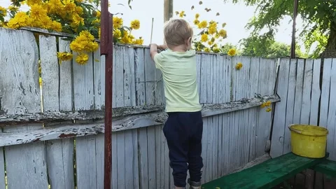 A small child is jumping on a bench near the fence. Height, injury, fall, pain Stock Footage 262383534