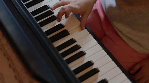 Small child learning piano reversed angle Stock Footage 55751930