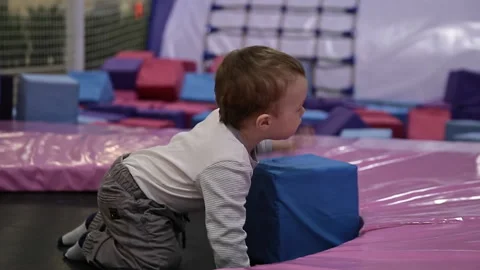 Small child learns to jump on trampoline, kid in trampoline park Stock Footage 291326749