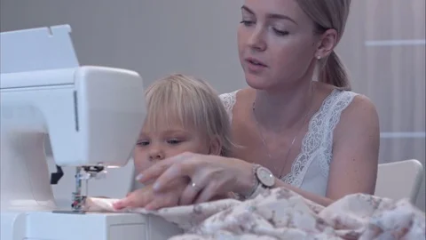 Small child learns new knowledge with her mother using sewing machine Vidéo 70194117