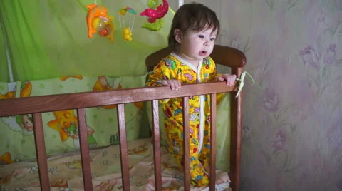 A small child learns to stand in the crib Stock-Footage 61197640