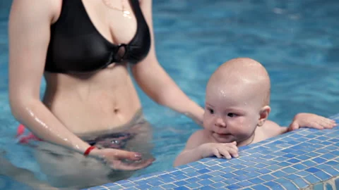 A small child learns to swim in the pool with his mother.Swimming pool with blue Stock-Footage 108290283