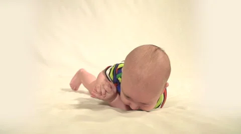 The Small Child Learns to Turn over Himself on Tummy Stock Footage 62948619
