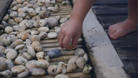 A small child learns the world and throws stones at the pool. slow motion Stock Footage 86787090