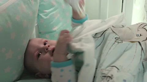 A small child is lying in a crib and looking at the camera.Close-up of the head. Stock Footage 163660323