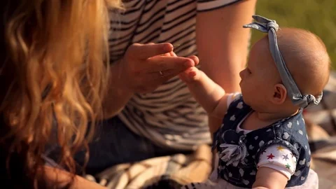 Small child with parents playing with grass Stock Footage