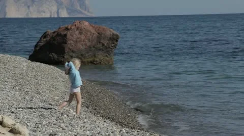 A small child playing on the beach. Video stock 22156628