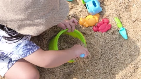 A small child is playing on the beach sand Stock Footage 276953432