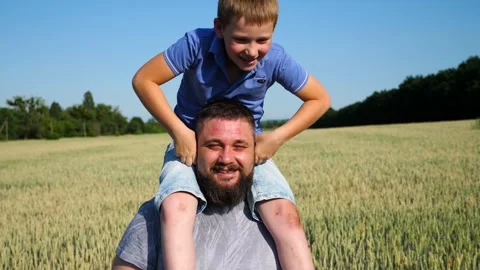 Small child playing with daddy ears sits on his shoulders. Happy family Video stock 252669156