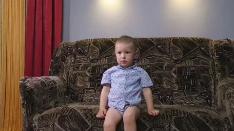 A small child is playing on a large sofa Stock Footage 132641631