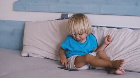 Small child playing smartphone on the bed Video stock 220732073