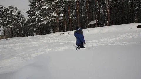 Small child playing in the snow Stock Footage 70289293