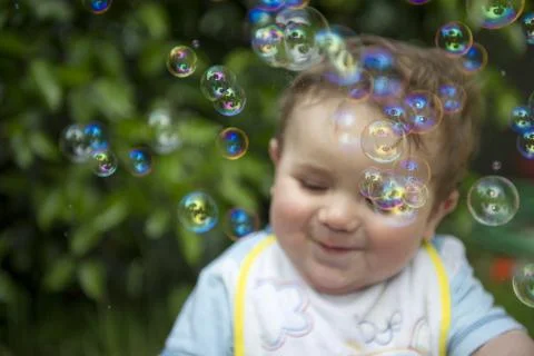 Small child playing with soap bubbles Foto stock
