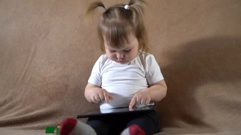 Small child playing on a tablet computer Stock Footage 237608231
