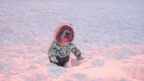 A small child is playing in winter Park. A Sunny winter day. Fun and games in Vidéo 85026640