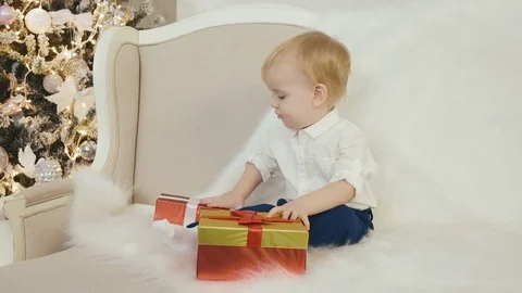 A small child plays beautiful boxes for gifts Video stock 75249179