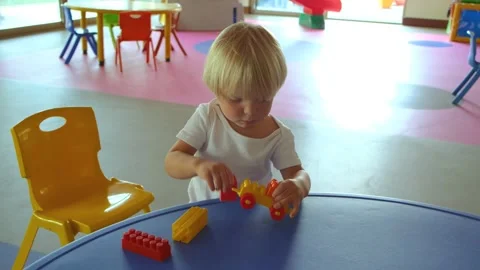 A small child plays with a construction set on the table Stock Footage 194777283