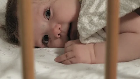 A small child plays in the crib. Video stock 127611550
