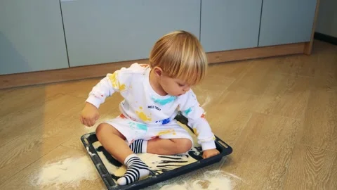 A small child plays with flour in the kitchen like sand sits in a kitchen Stock Footage 201458935