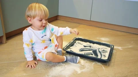 A small child plays with flour in the kitchen like sand Stock Footage 201458959