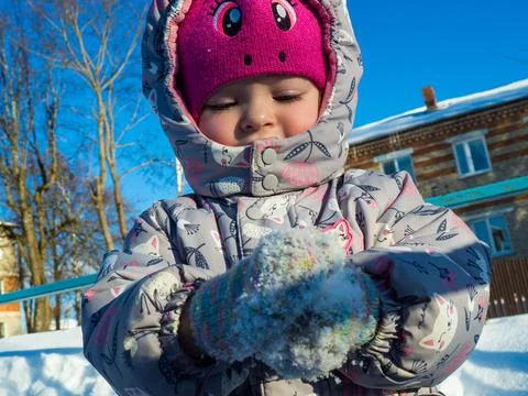 A small child plays on the playground with snow. Stock Photos