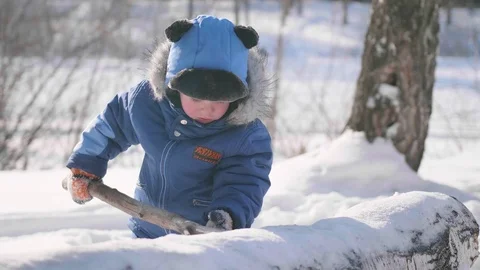 A small child plays in the winter Park, laughs and smiles . Sunny frosty day Vidéo 85893360