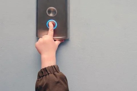 A small child presses the elevator call button. Baby reaches for the elevator Fotos de archivo