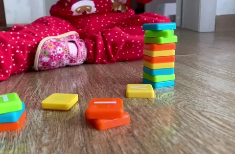 A small child in a red suit, immersed in the fascinating process of assembling Stock Footage 263328344
