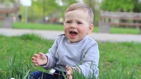 A small child rejoices at soap bubbles in nature and claps his hands Video stock 201325554