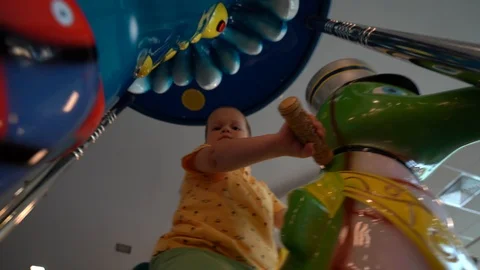 A small child riding on a children's carousel Stock Footage 109112466