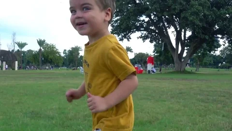Small child running all around, parent walking in the background. 4k 2017 Video stock 82070402