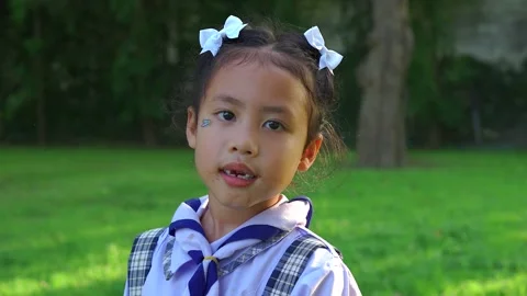 Small child in school uniform lost her first teeth smiling to camera. Stockbeeldmateriaal 255203840
