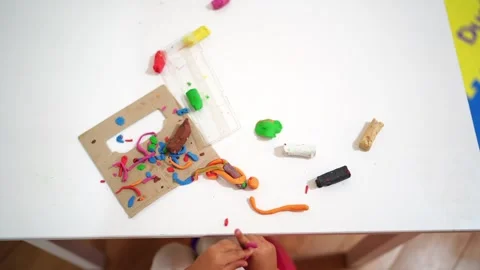 Small child sculpts from plasticine at the table. Cropped Stock Footage 285902372