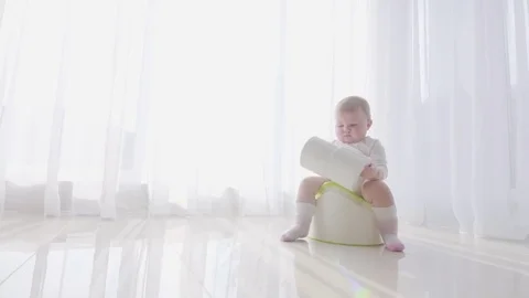 Small child sits on the potty and relieves itself Stock Footage 73767103