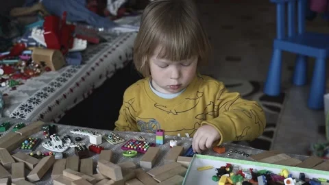 A small child sits at the table and eats organic food from a plate. Stock Footage 239641487