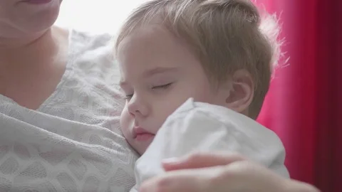 A small child sleeping on hands at mum. The tenderness and care of children. 動画素材 82393960