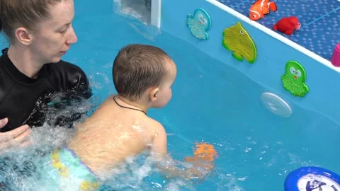 Small child spending fun time in swimming pool. Concept of active leisure Video stock 175374403
