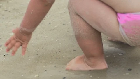 A small child splashing in the water on the beach. Slow motion Stock Footage 101974908