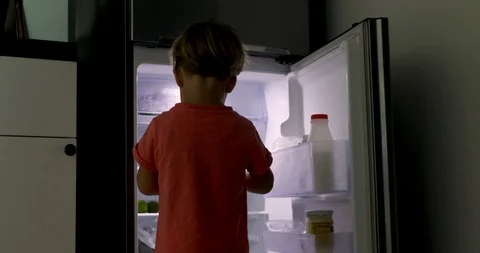 Small child stands open refrigerator takes milk Stock Footage 105817561