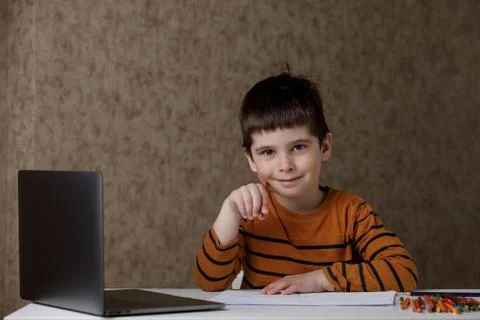 A small child is studying at the computer. Distance learning at home quarantine Stock Photos